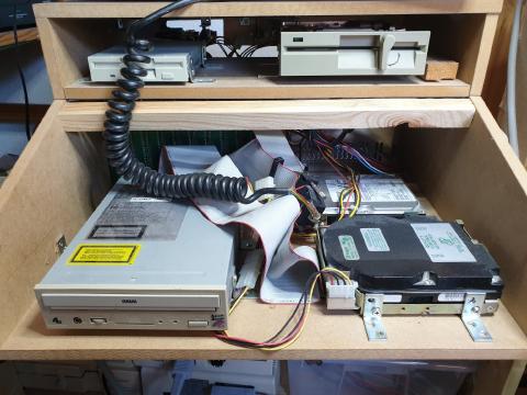 A wooden case without keyboard to expose a CD drive and two harddisks