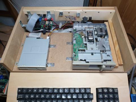 A wooden case with the top taken away to expose the two disk drives