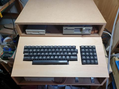 A wooden case with a PET keyboard and two PC disk drives
